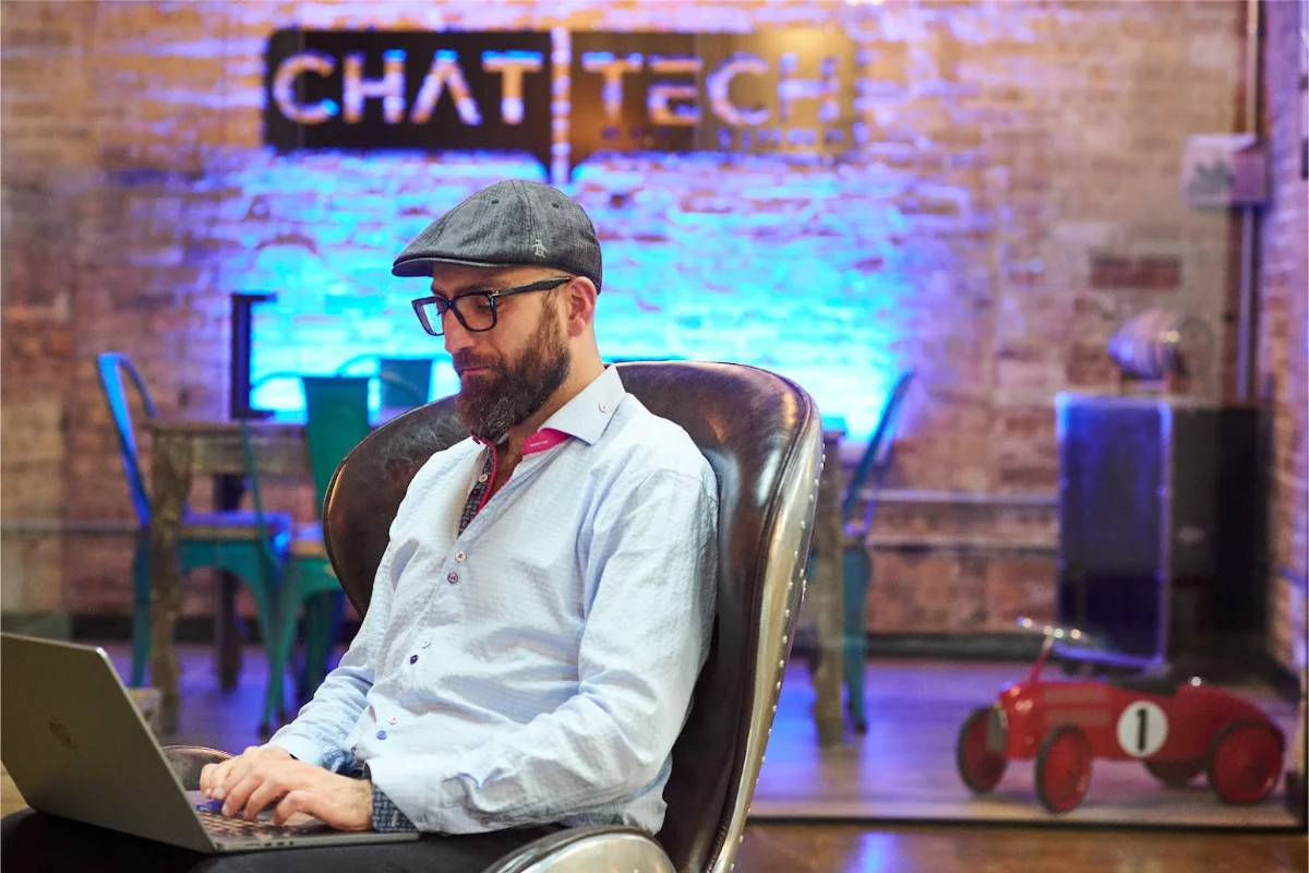Burak sitting in Chat Tech offices working on his laptop